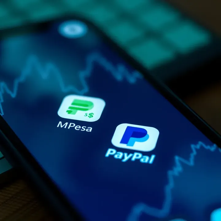 Digital mobile phone screen displaying M-Pesa and PayPal app icons with currency exchange symbols
